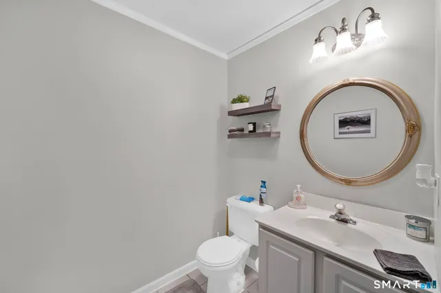 a bathroom with a toilet sink vanity and mirror