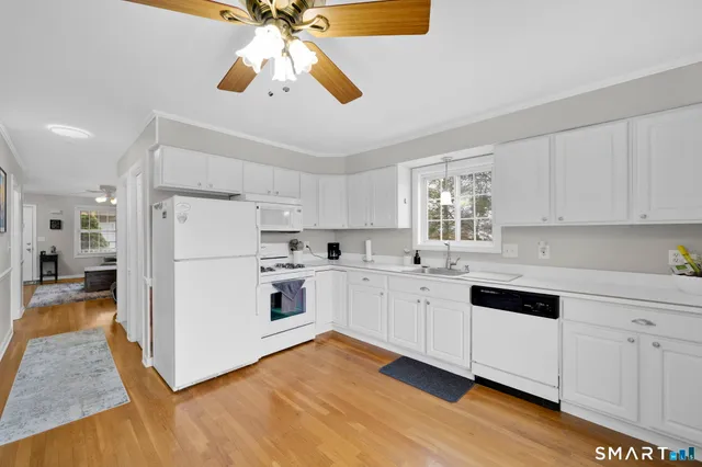 a kitchen with white cabinets and white appliances