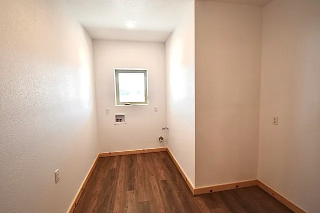 a view of a room with wooden floor and white walls