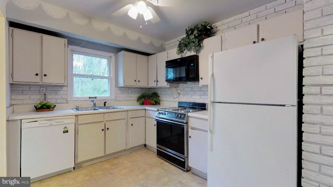 11730 Perry Branch Road Newburg, MD 20664 - Photo 11 of 27 a kitchen with stainless steel appliances a refrigerator sink and white cabinets