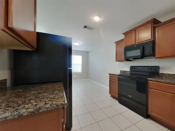 a kitchen with stainless steel appliances granite countertop a stove a sink and a microwave