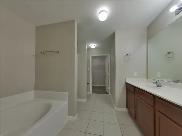 a spacious bathroom with a bathtub sink and mirror