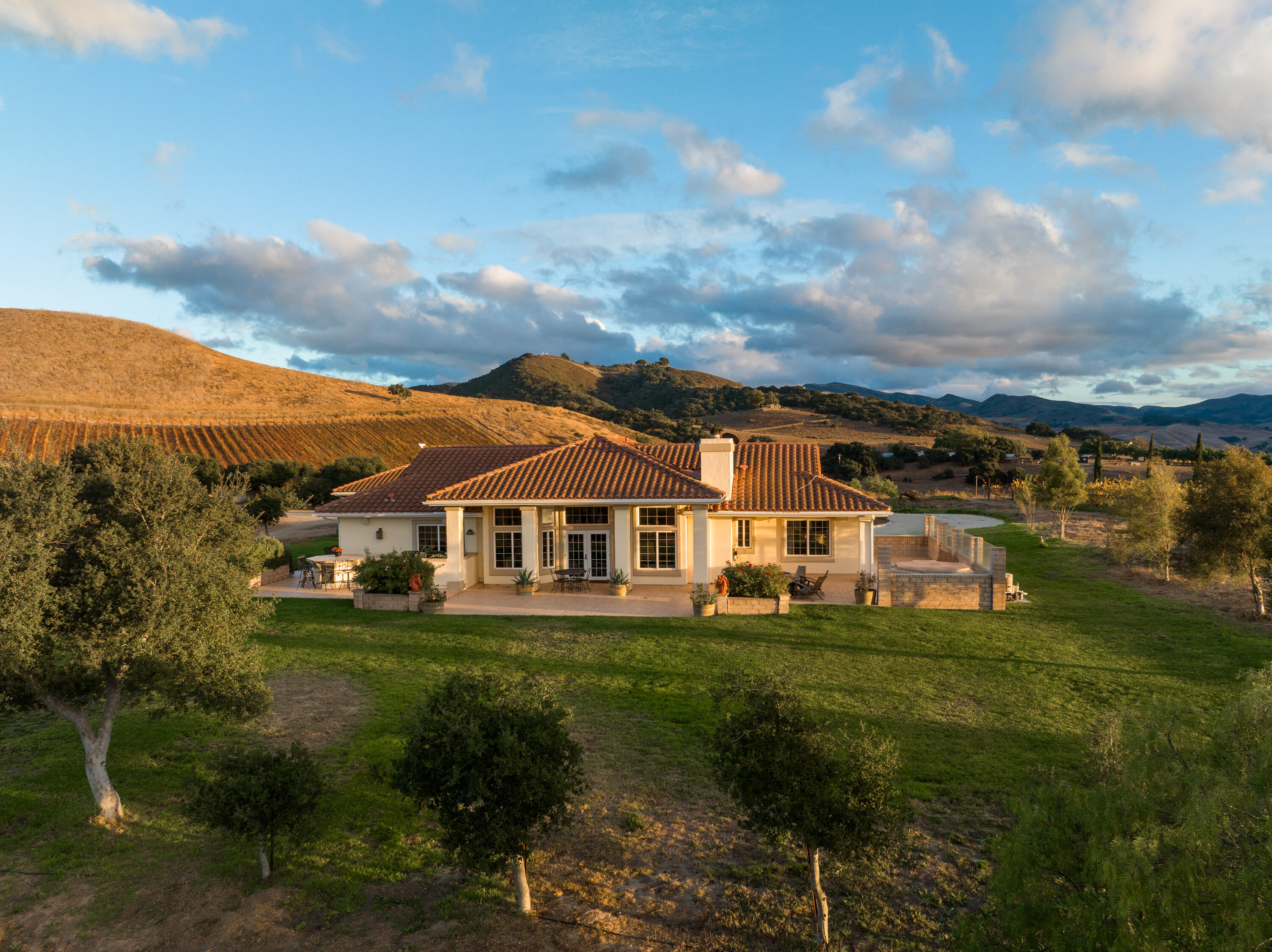 7253 Santos Road Lompoc, CA 93436 - Photo 19 of 28 a view of a white house with a big yard and potted plants