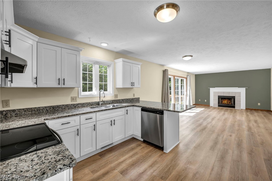 9842 Johnnycake Ridge Road Mentor, OH 44060 - Photo 9 of 40 Open-concept kitchen featuring white shaker cabinetry, stainless steel appliances, and granite countertops