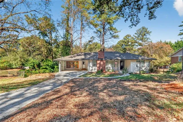a view of a house with a yard and tree s