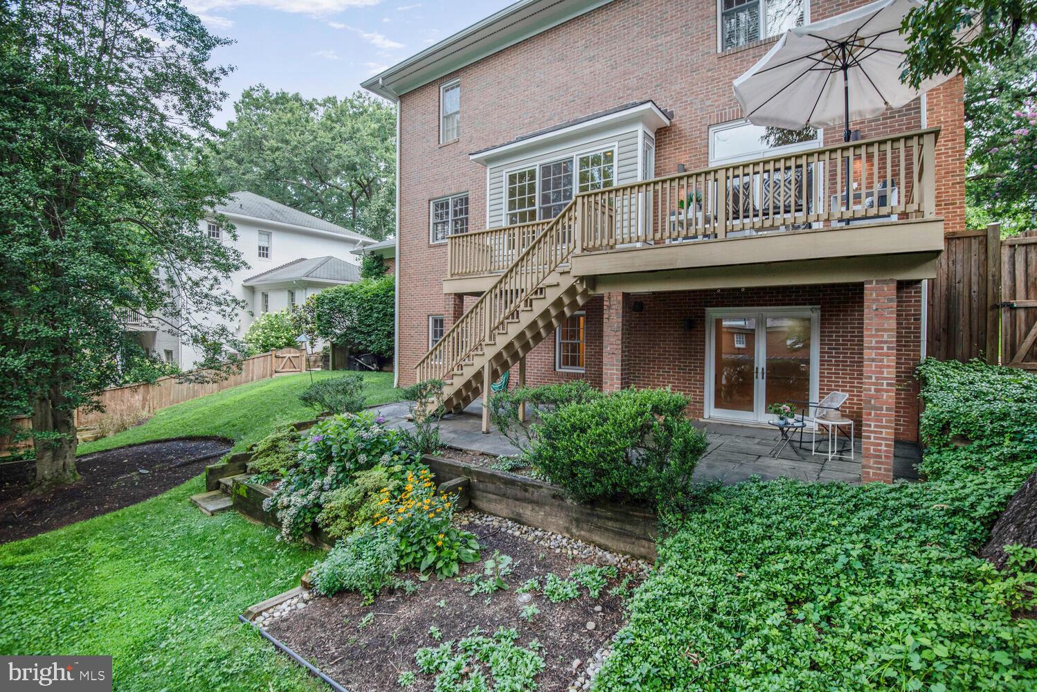 5222 Loughboro Road Northwest Washington, DC 20016 - Photo 43 of 47 a view of a brick house with a small yard plants and large tree