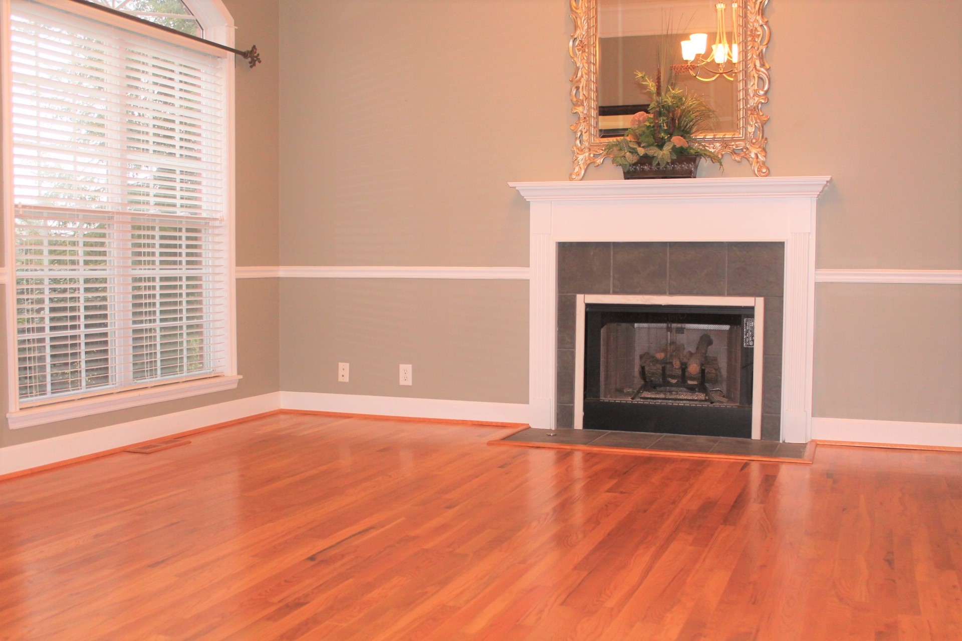 608 Fowler Ford Road Portland, TN 37148 - Photo 12 of 50 a view of an empty room with wooden floor fireplace and a window