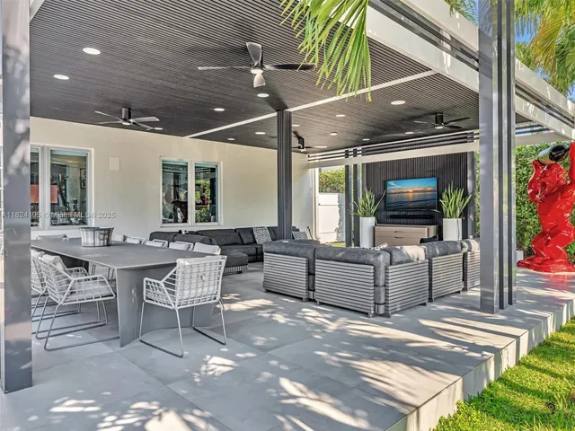 a living room with stainless steel appliances dining table furniture and a large window