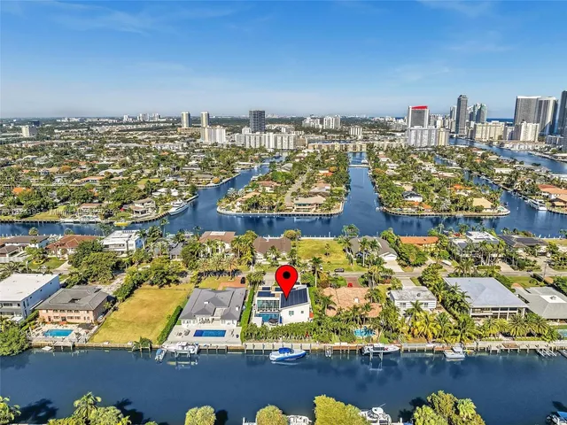 an aerial view of residential houses with outdoor space and trees