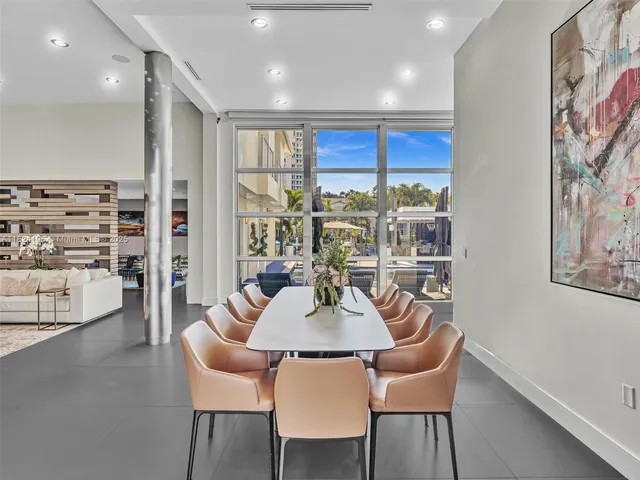 a living room with furniture kitchen view and a wooden floor