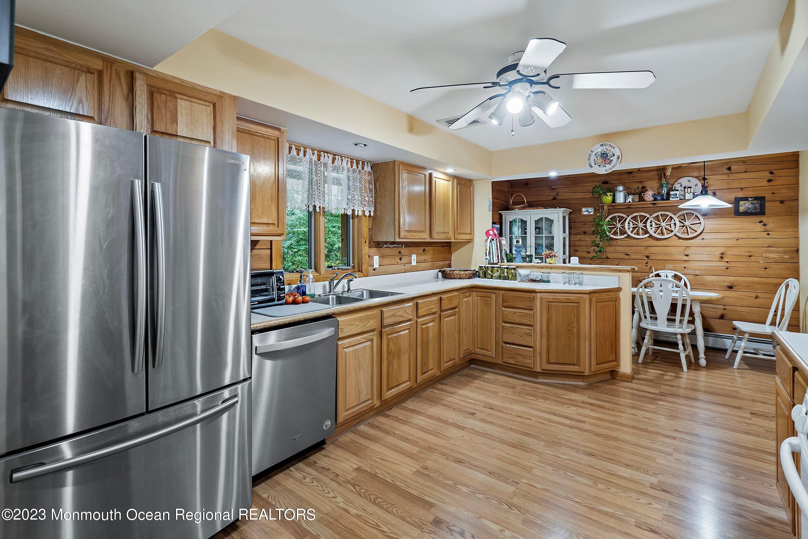 172 Jackson Mills Road Freehold, NJ 07728 - Photo 9 of 20 a kitchen with stainless steel appliances a refrigerator a sink dishwasher a stove and a dining table with wooden floor