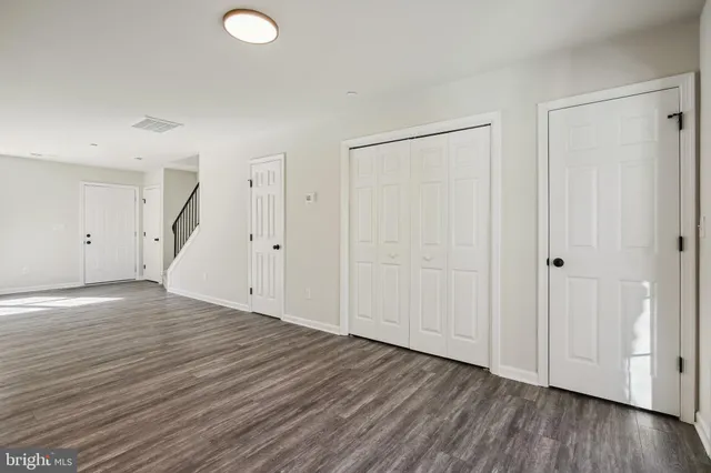 a view of an empty room with wooden floor and entryway