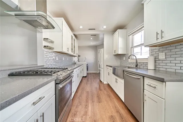 a kitchen with stainless steel appliances granite countertop a stove and a sink