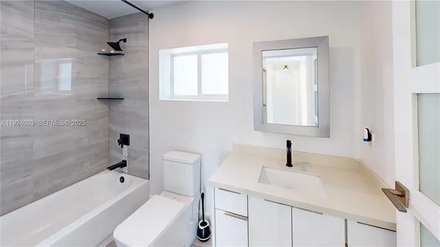 a bathroom with a sink toilet vanity and bathtub