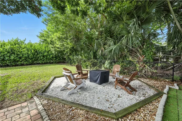 a view of a backyard with chair and potted plants