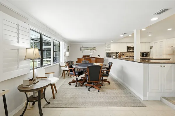 a living room with furniture a table and kitchen view