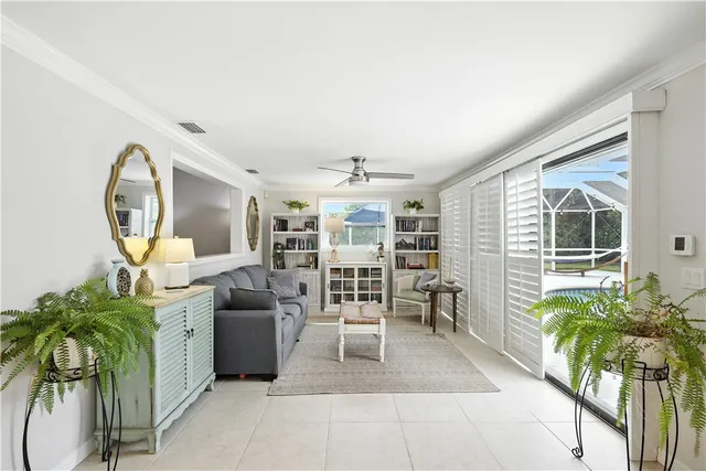 a living room with furniture a potted plant and a large window