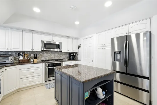 a kitchen with white cabinets and stainless steel appliances