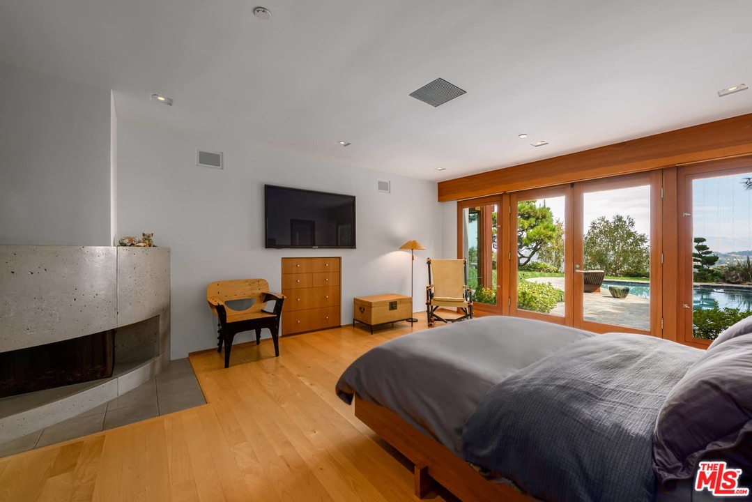 2238 Stradella Road Los Angeles, CA 90077 - Photo 25 of 54 a bedroom with a bed chair and flat screen tv