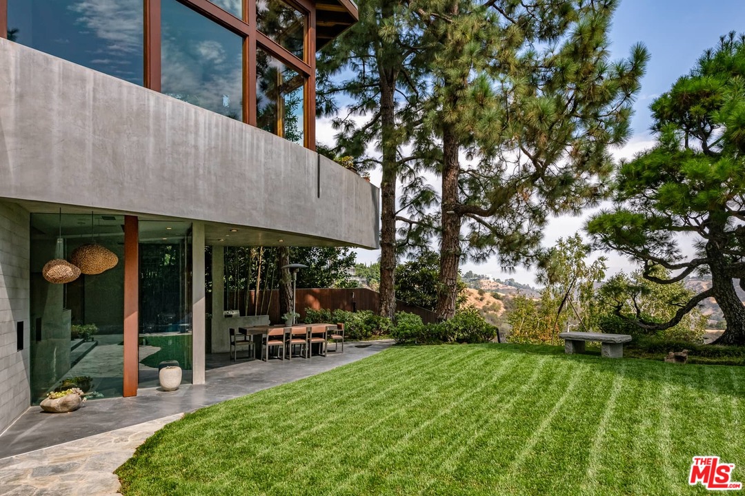 2238 Stradella Road Los Angeles, CA 90077 - Photo 51 of 54 a view of a patio with table and chairs potted plants and large tree