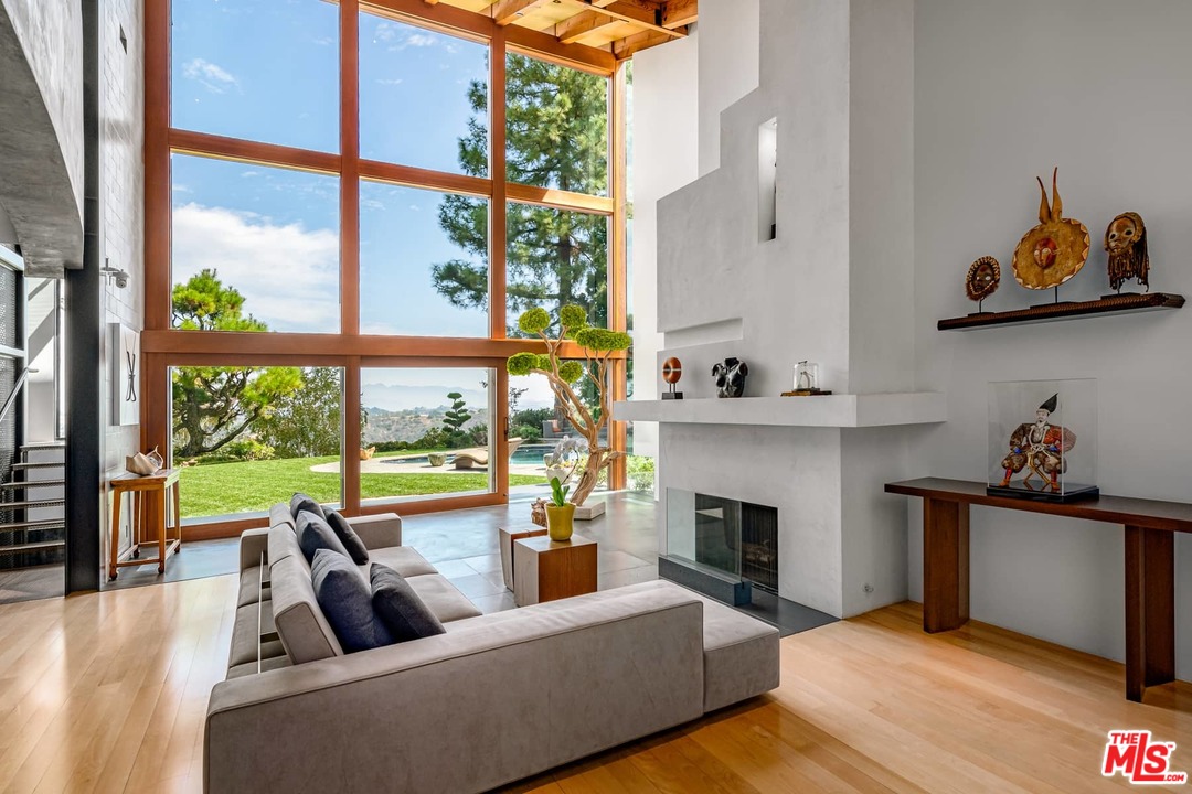 2238 Stradella Road Los Angeles, CA 90077 - Photo 7 of 54 a living room with furniture a fireplace and a floor to ceiling window