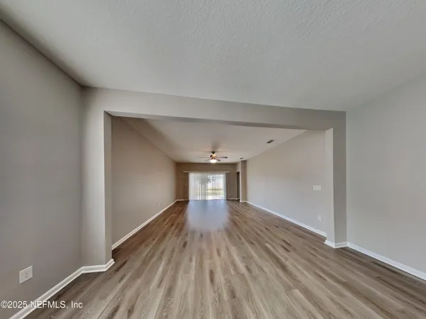 a hallway view with wooden floor and staircase