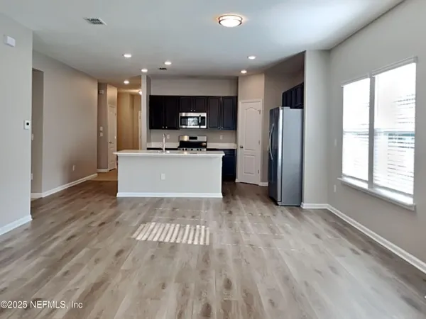 a view of kitchen with stainless steel appliances granite countertop a refrigerator oven a sink dishwasher and a microwave with wooden floor