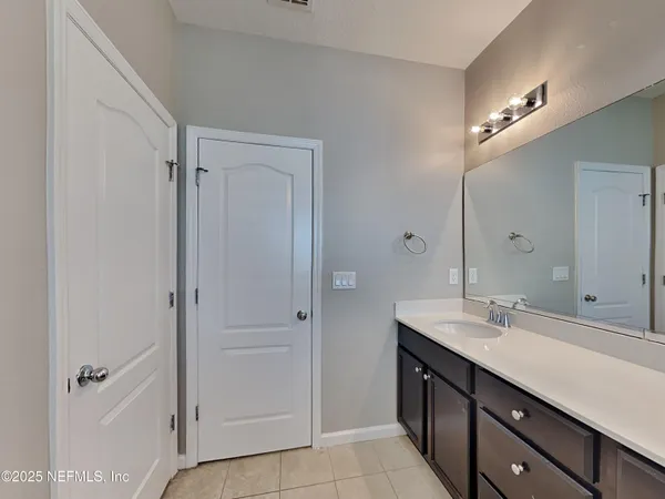 a bathroom with a double vanity sink a mirror and a shower
