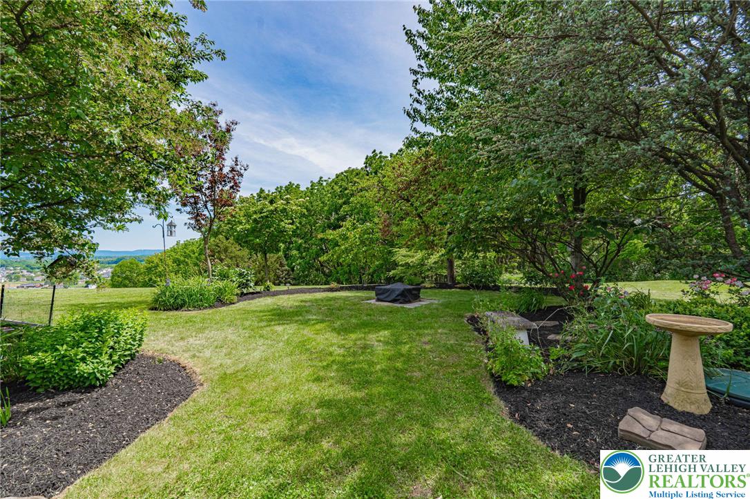 4542 Springfield Drive Coplay, PA 18037 - Photo 68 of 89 A verdant lawn framed by mature trees, offering a private yard with distant hillside views.
