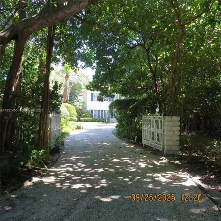 a view of a street with trees and bushes