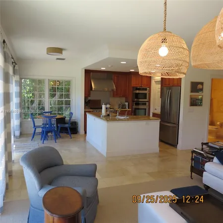 a living room with furniture a flat screen tv and kitchen view