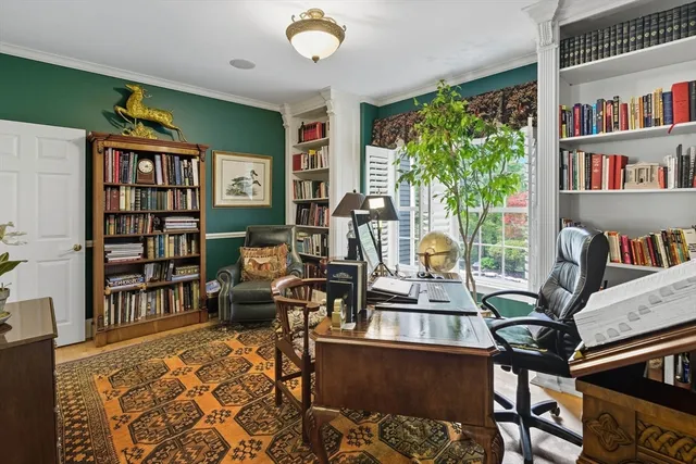 a living room with furniture a bookshelf and a large window