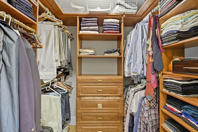 a view of walk in closet with clothes and shoes