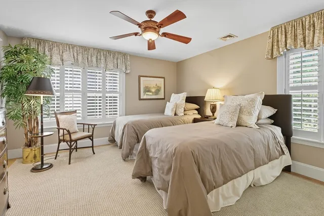 a bedroom with a bed a chandelier and a large window