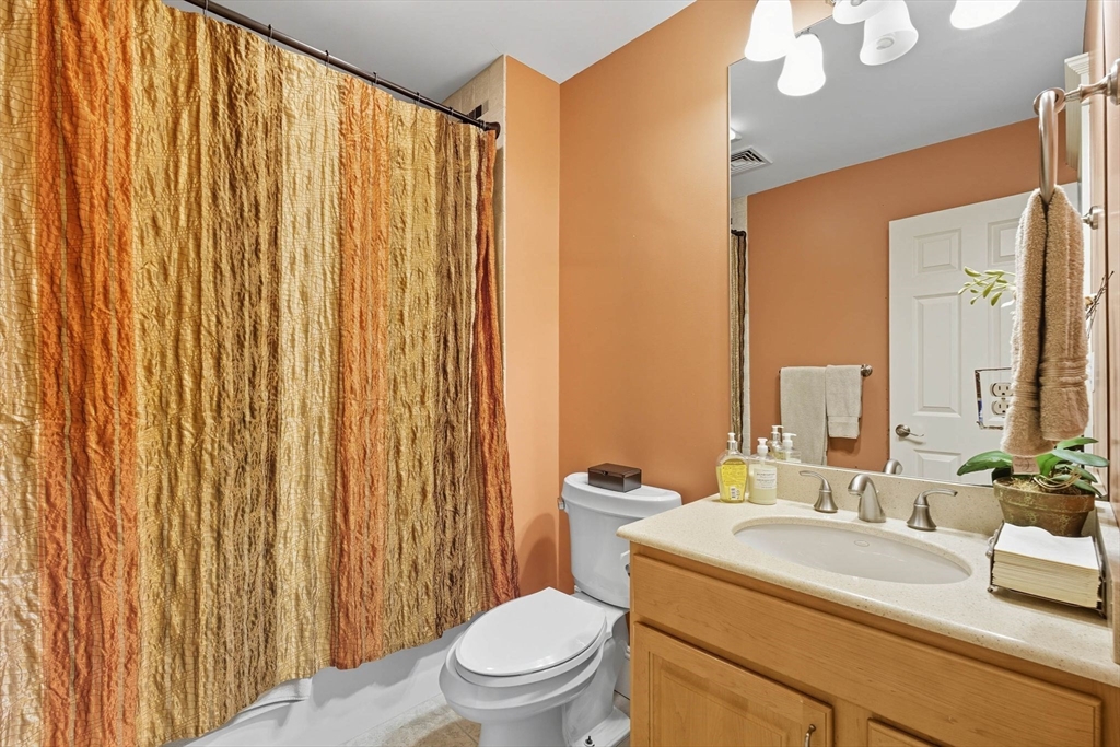 3 Warren Drive Middleton, MA 01949 - Photo 37 of 42 a bathroom with a sink a toilet a mirror and shower curtain