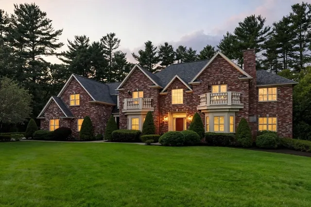 a front view of a house with a yard and trees