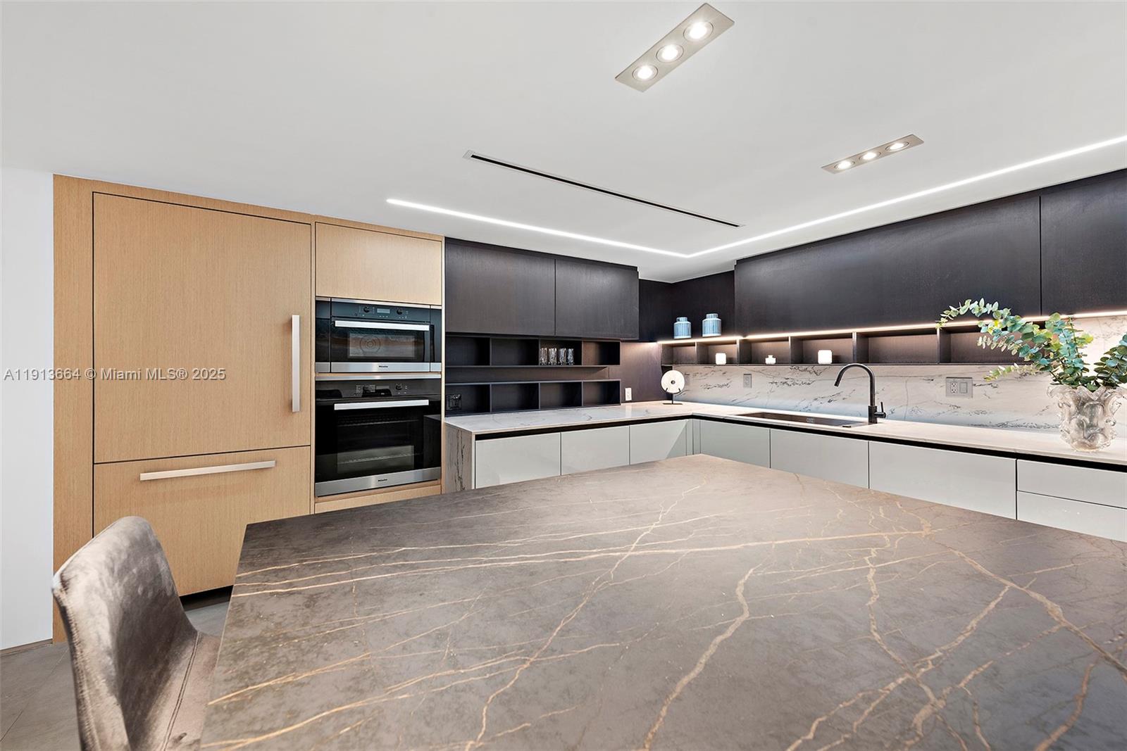 2301 Collins Avenue, Unit 1004 Miami Beach, FL 33139 - Photo 26 of 53 a view of kitchen with stainless steel appliances wooden cabinets and stove top oven