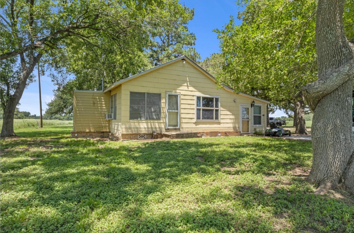 451 Pleasant Grove Road Elgin, TX 78621 - Photo 3 of 26 a view of a yard in front of a house with large trees