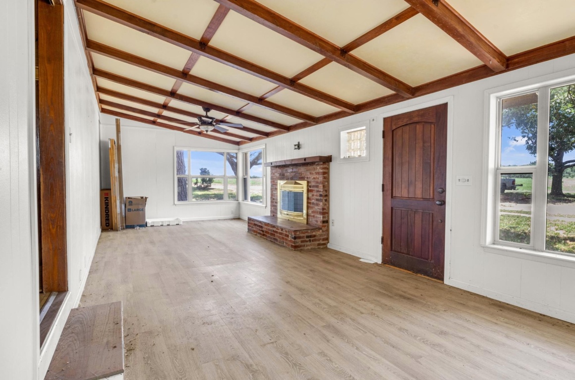 451 Pleasant Grove Road Elgin, TX 78621 - Photo 4 of 26 a view of an empty room with wooden floor and a window
