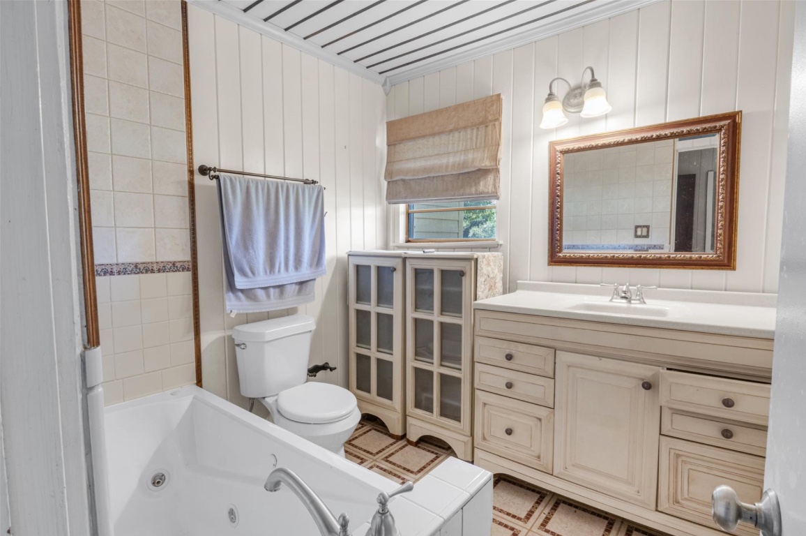 451 Pleasant Grove Road Elgin, TX 78621 - Photo 7 of 26 a bathroom with a granite countertop sink vanity mirror bathtub shower