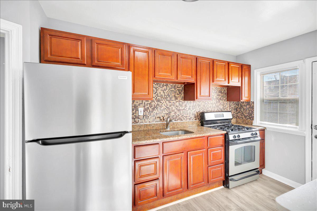 a kitchen with stainless steel appliances granite countertop a refrigerator sink and cabinets