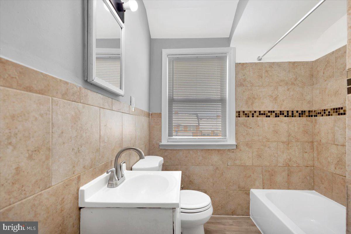 929 East 41st Street Baltimore, MD 21218 - Photo 13 of 18 a bathroom with a toilet a sink and mirror