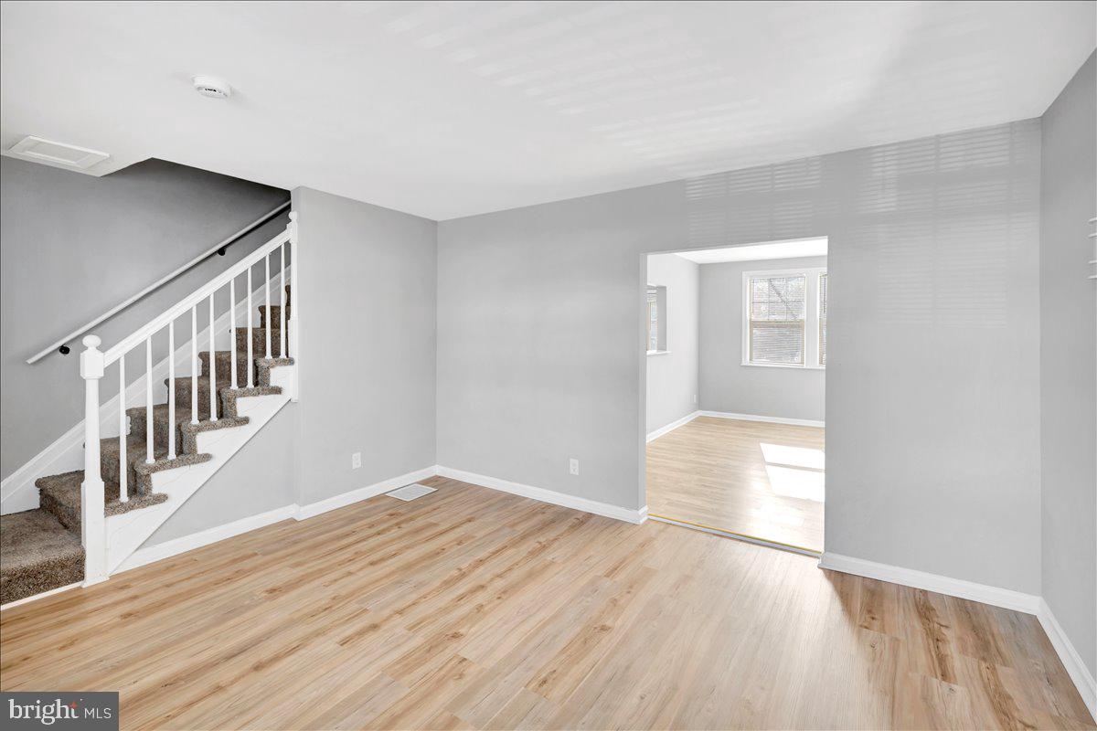 929 East 41st Street Baltimore, MD 21218 - Photo 5 of 18 a view of an empty room with wooden floor and a window