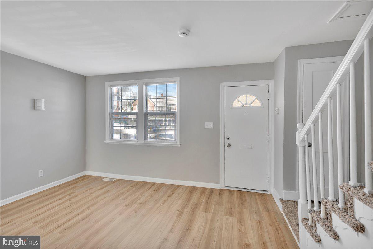 929 East 41st Street Baltimore, MD 21218 - Photo 7 of 18 a view of an empty room with wooden floor and a window