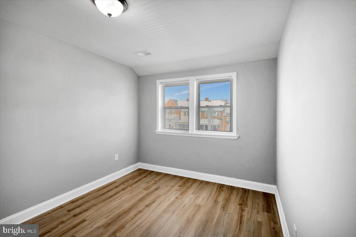 929 East 41st Street Baltimore, MD 21218 - Photo 10 of 18 an empty room with wooden floor and windows