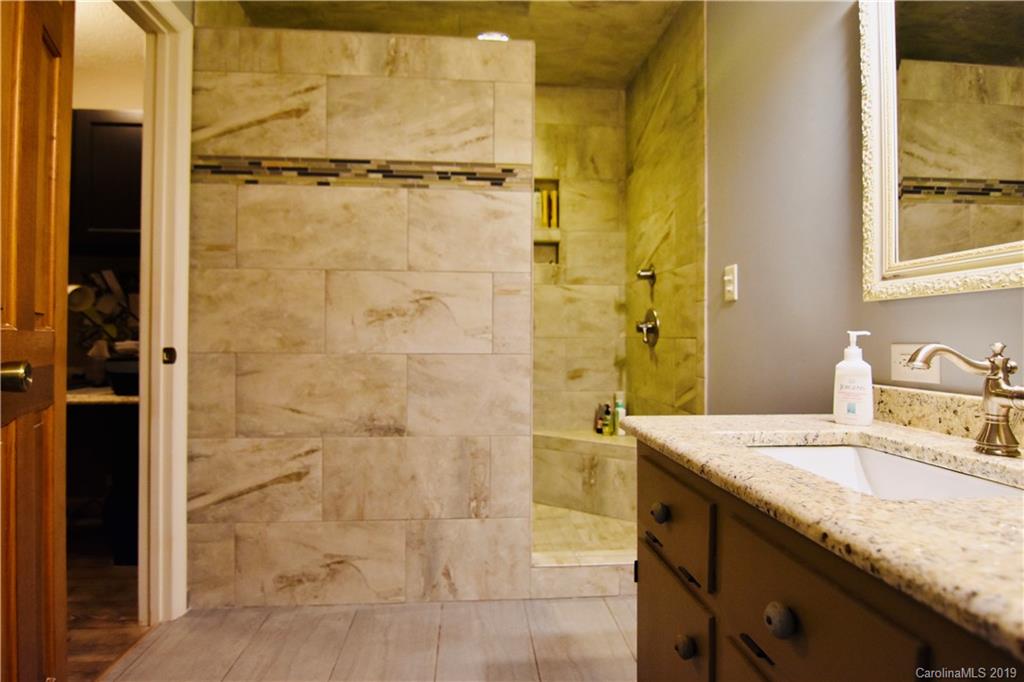 326 Baucom Deese Road Monroe, NC 28110 - Photo 22 of 42 a bathroom with a granite countertop shower a sink and a mirror