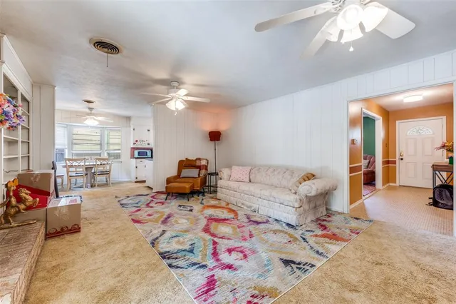 a living room with furniture a flat screen tv and a large window