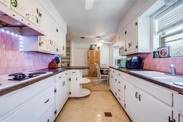 a kitchen with granite countertop lots of white cabinets and a stove