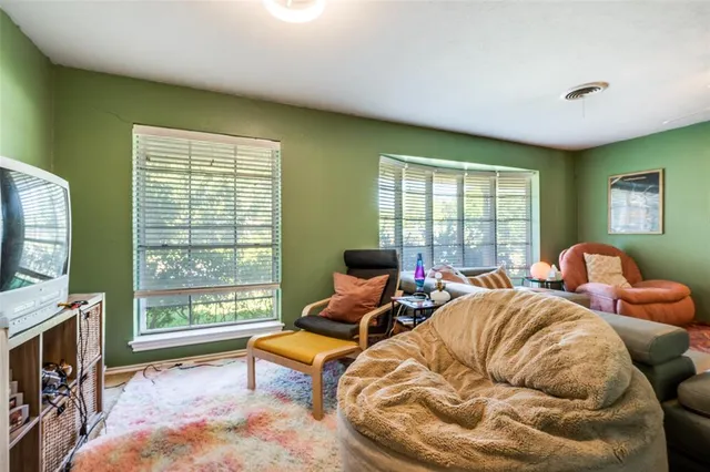 a living room with furniture a flat screen tv and a large window