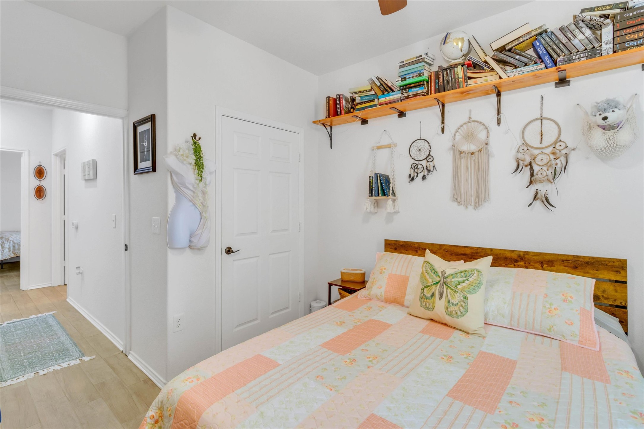 460 Waterleaf Boulevard Kyle, TX 78640 - Photo 19 of 30 A cozy bedroom features light wood flooring and a sturdy wooden headboard, creating a welcoming retreat.